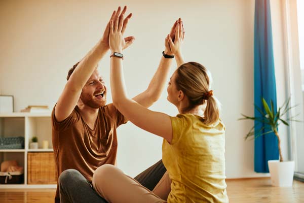 cheerful couple giving each other high five for working together as a team